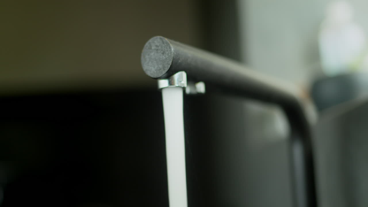 Water flows from a modern kitchen faucet. Slider shot