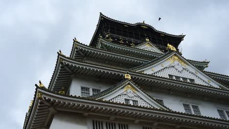 close up view of osaka castle with crows flying