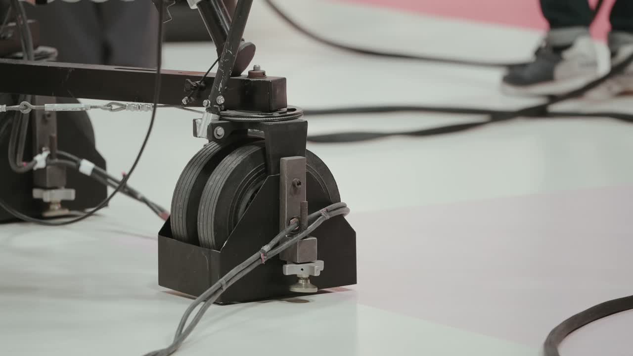 Close up of professional camera dolly wheels on studio floor during broadcast setup and technical preparation