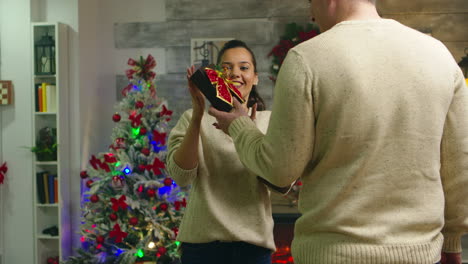 young boyfriend hiding christmas gift behind his back