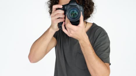fotógrafo mostrando una tarjeta de visita mientras toma una foto con una cámara digital