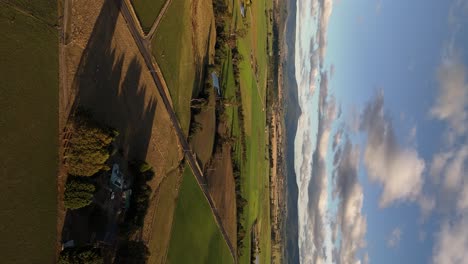 Aerial-vertical-shot-of-idyllic-scenery-with-colorful-fields-in-sunset