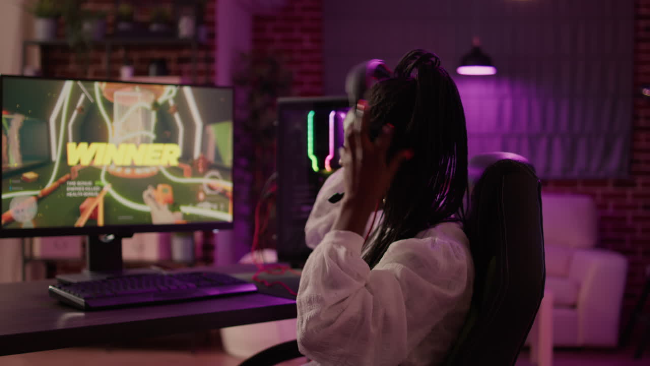Over shoulder view of woman streaming first person shooter doing victory hand gesture after win