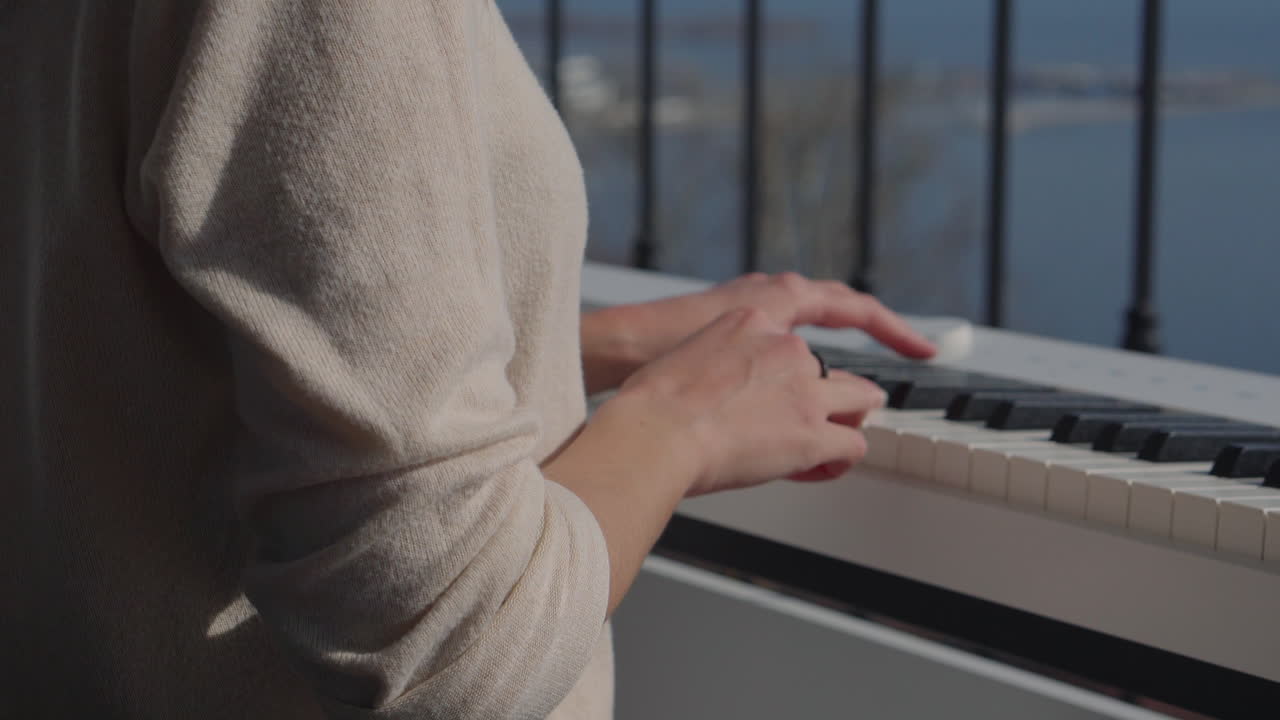 mujer tocando el piano en un balcón con una vista