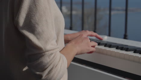 woman playing piano on a balcony with a view