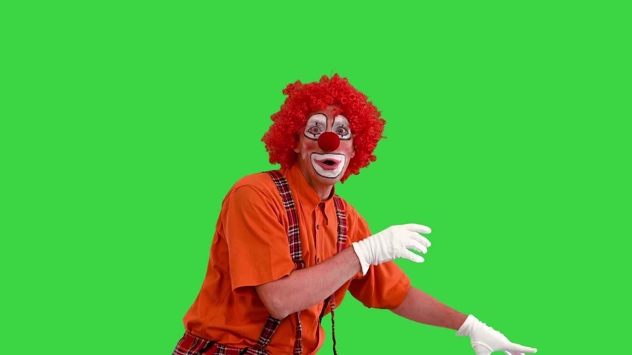 actor vestido como un payaso buscando una manera de actuar de una manera divertida en una pantalla verde, clave de croma