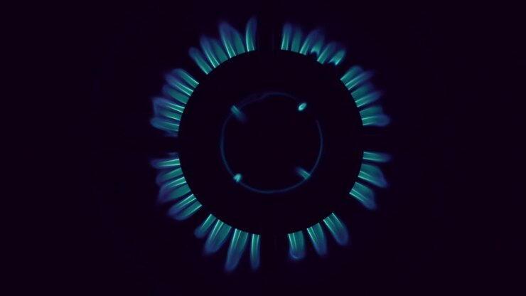 Vista dall'alto su bruciatore di fornello a gas con fiamma blu