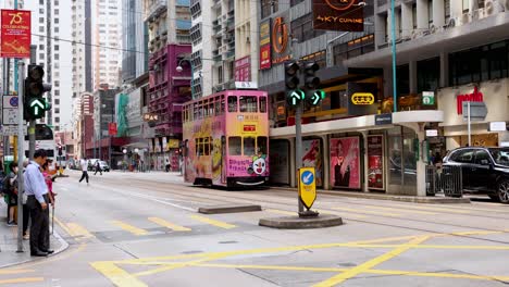 el tranvía se mueve a través de la concurrida intersección de hong kong.