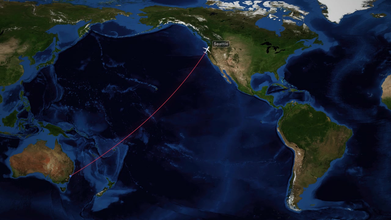 A red line tracks an airplane flying across the Pacific Ocean on a world map