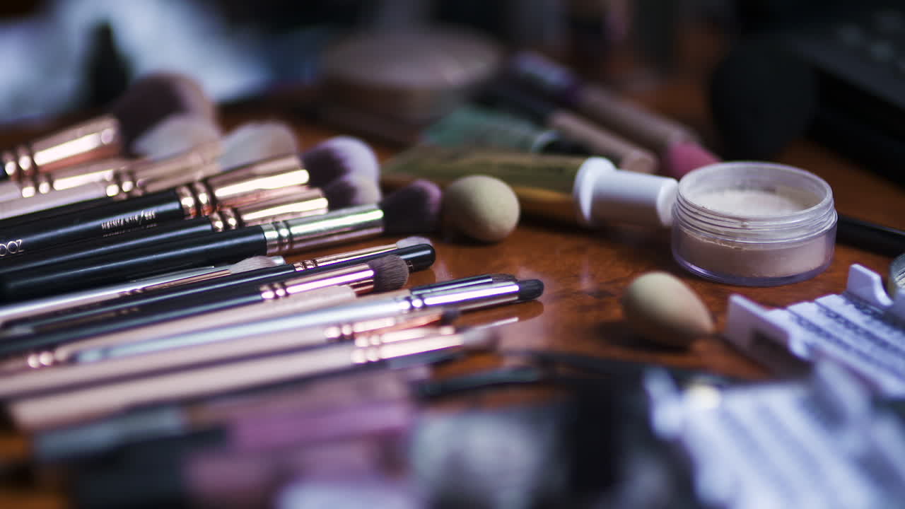 Primo piano di vari pennelli per il trucco e cosmetici su un tavolo
