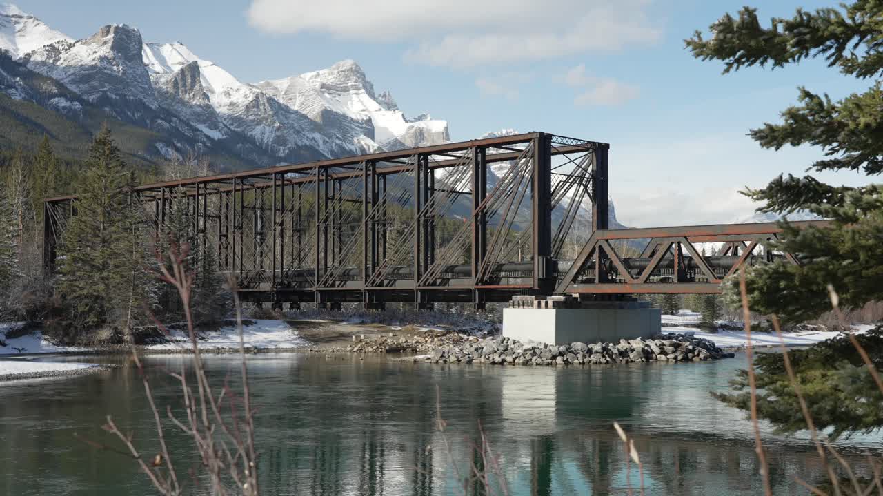 timelapse of people walking on the engine bridge in Canmore alberta. The bow river flows on by. Medium shot.