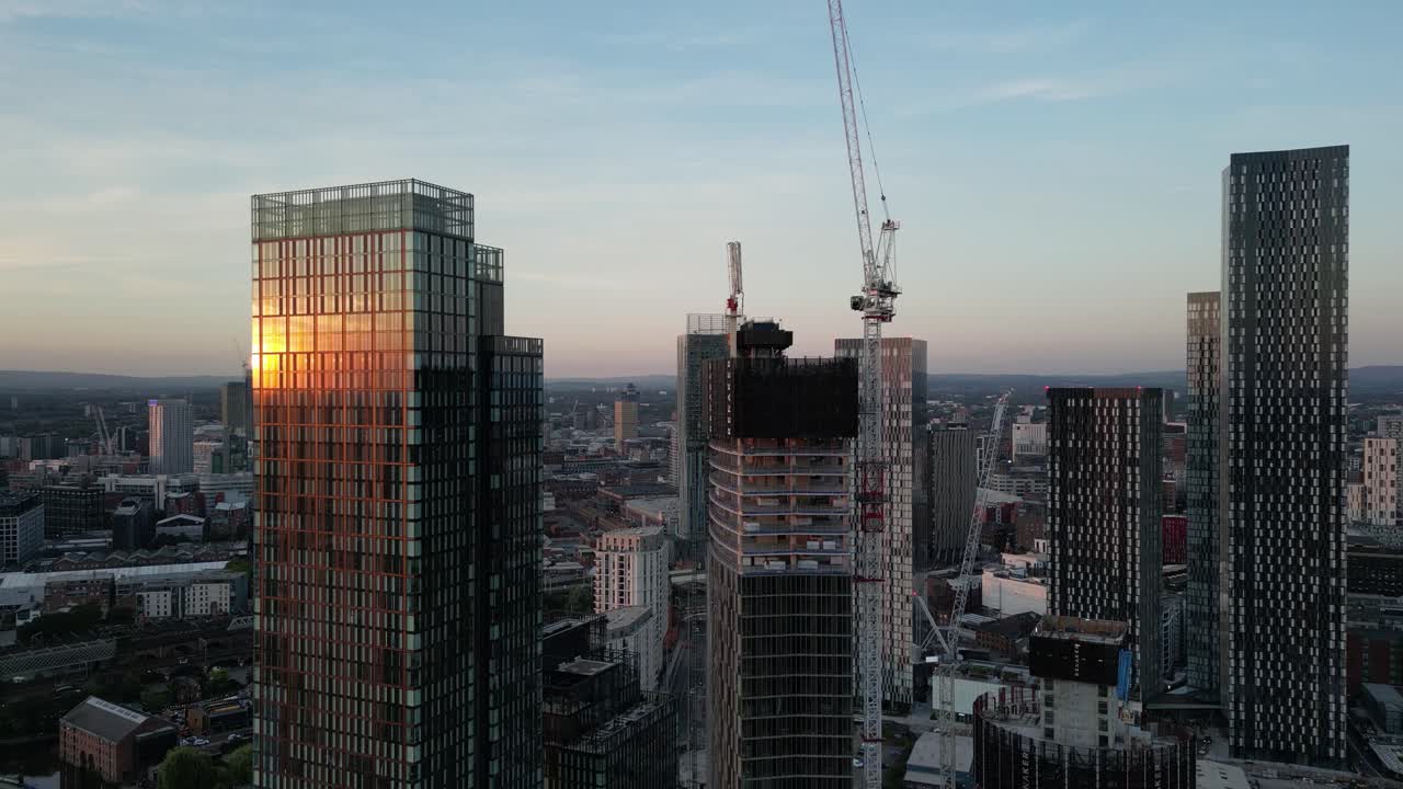 vuelo aéreo de drones en manchester alrededor de las torres deansgate y nueva construcción de rascacielos con la puesta de sol en el reflejo del vidrio