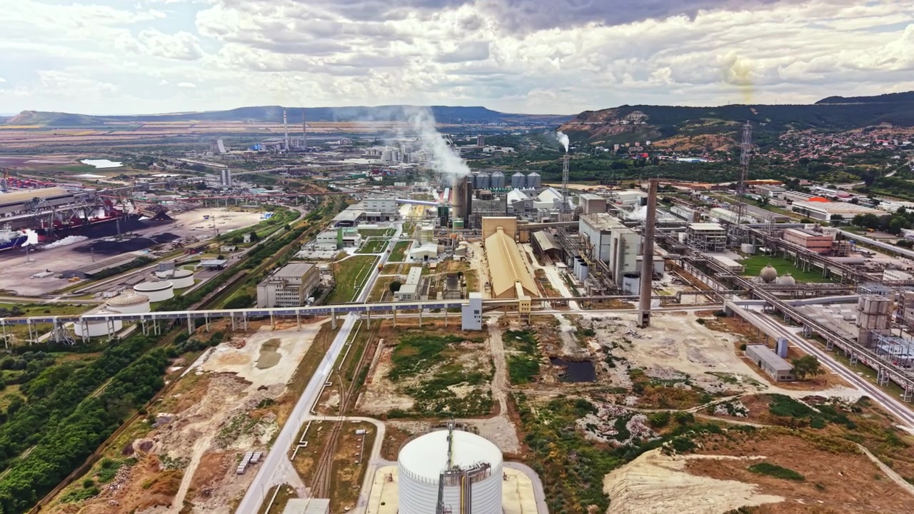 Visão geral de uma grande área industrial com fábricas e instalações localizada perto de uma serra em um dia nublado
