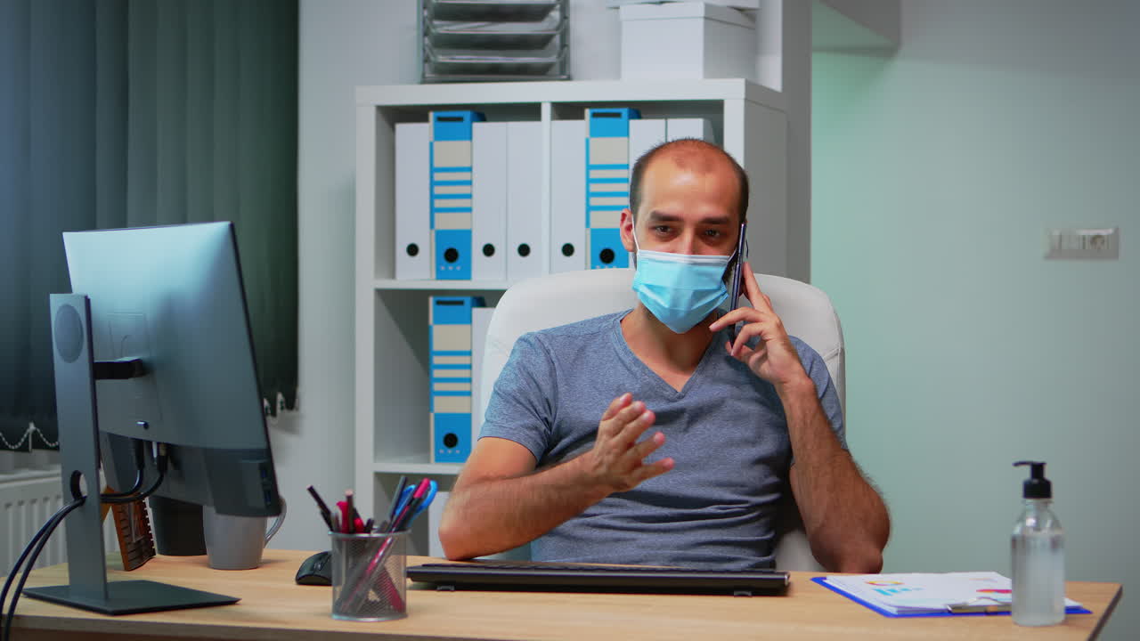Freelance con mascherina che parla al telefono cellulare.