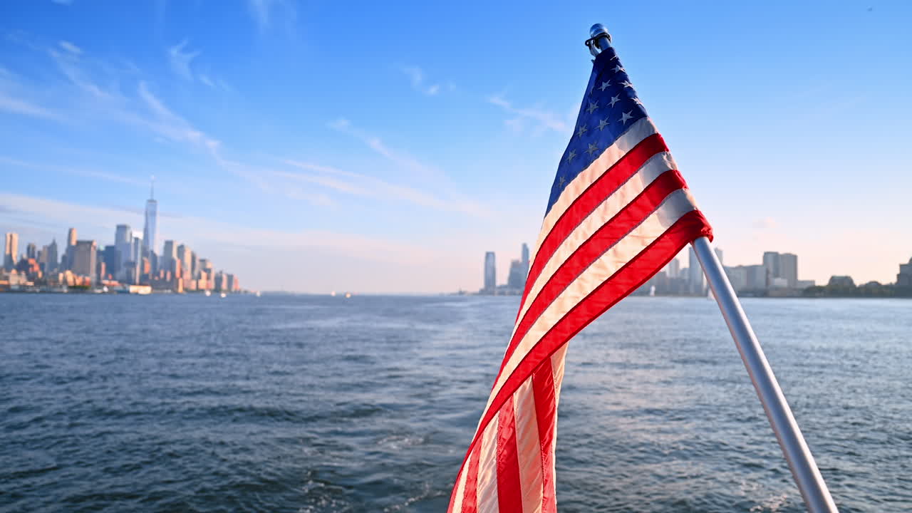 Bandiera americana sventola sullo skyline della città. Una vibrante bandiera americana sventola mentre una barca naviga sull'acqua, mostrando lo skyline di una città vivace.