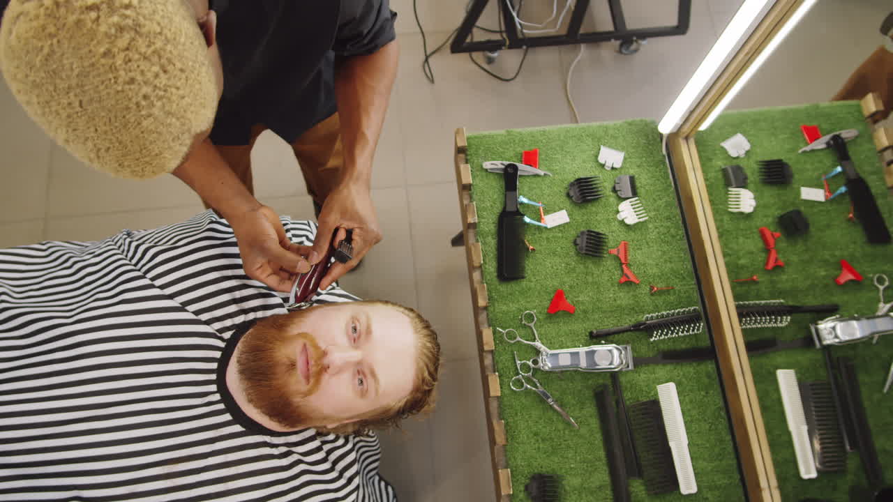 abajo de la parte superior del hombre recibiendo la barba recortada en la barbería
