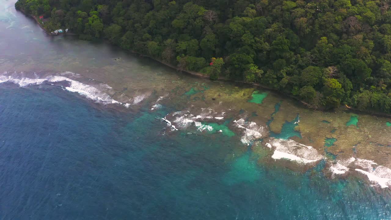 Overhead aerial view pan across Panama coral reef tropical island palm tree jungle landscape