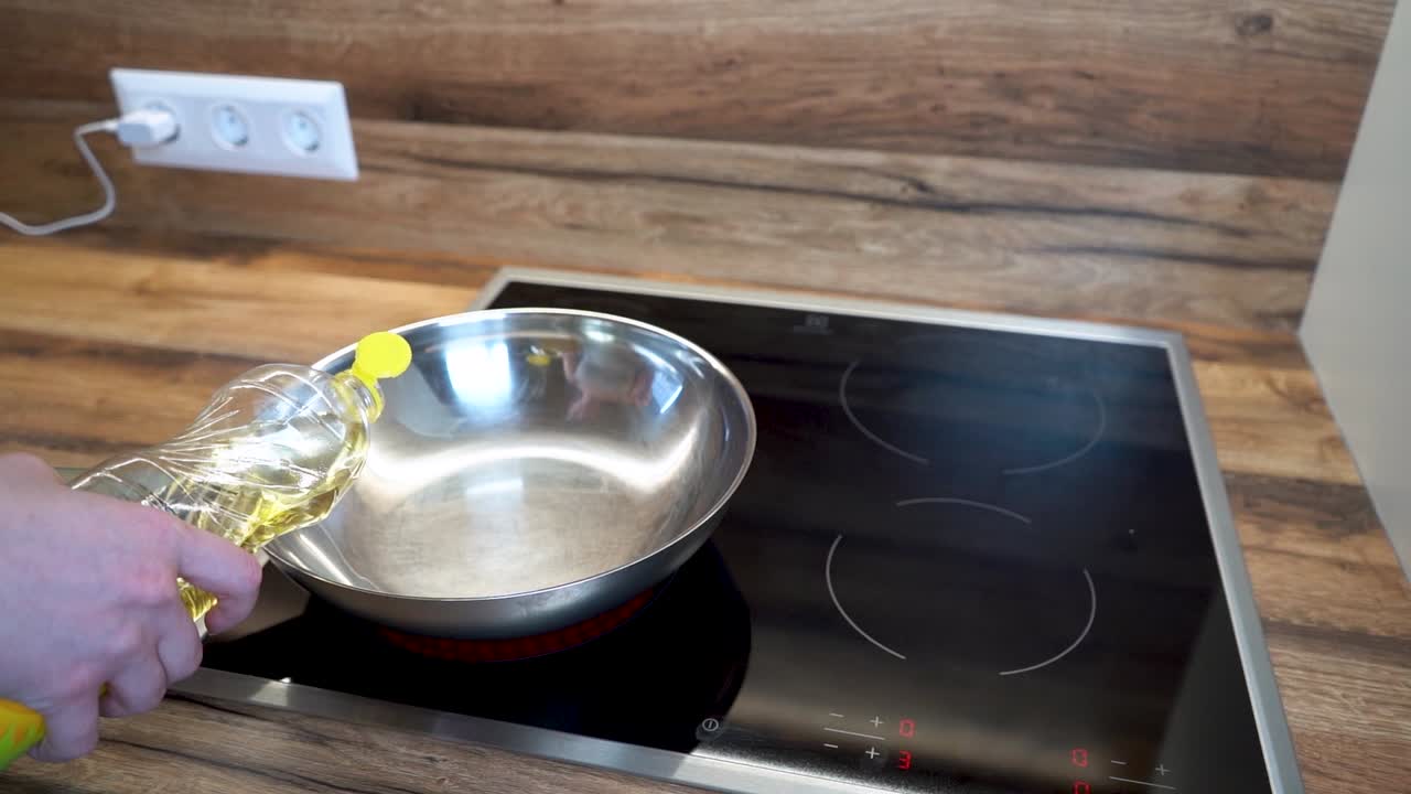 Woman Pourring Oil to a Frying Pan on an Electric Hot Plate