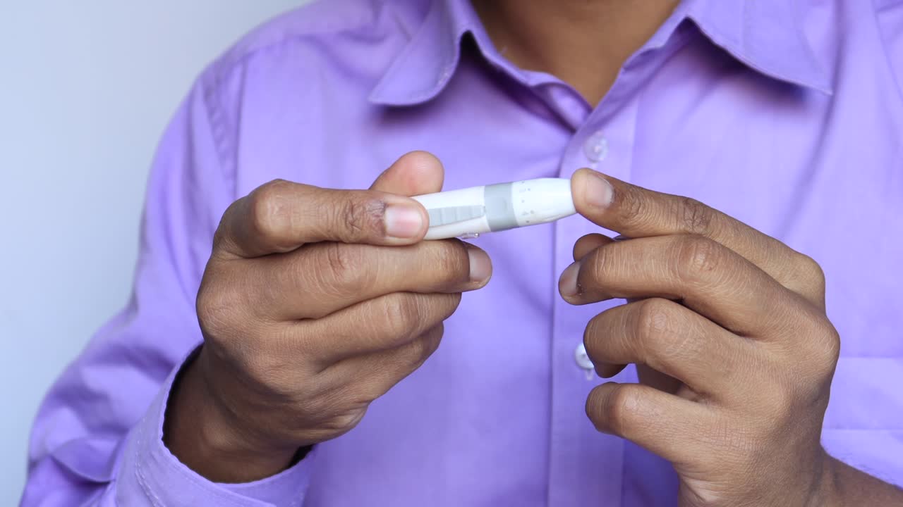 Young mans hand measure glucose level at home