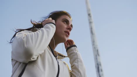 young woman listening to music before running