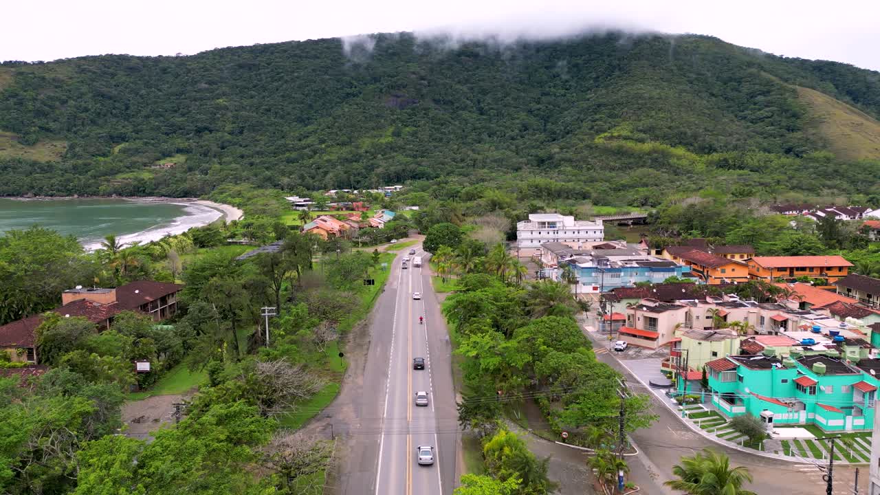 coches en la carretera de la costa brasileña con montaña neblinosa - playa de caraguatatuba - brasil