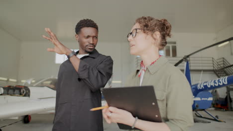 mechanic and engineer discussing aircraft maintenance in hangar