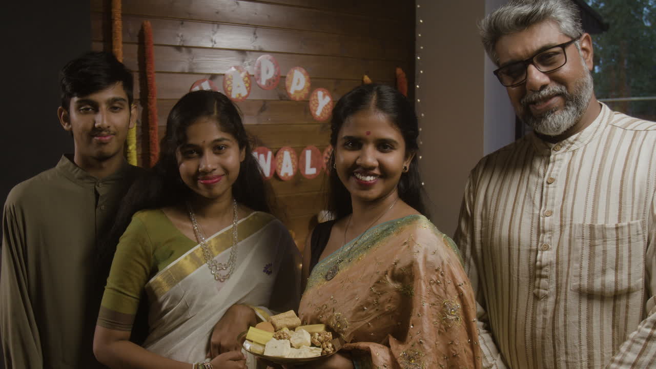 Family celebrating Diwali with traditional clothing and sweets