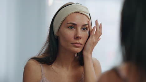 smiling lady looking mirror bathroom closeup. stunning woman touching fresh skin