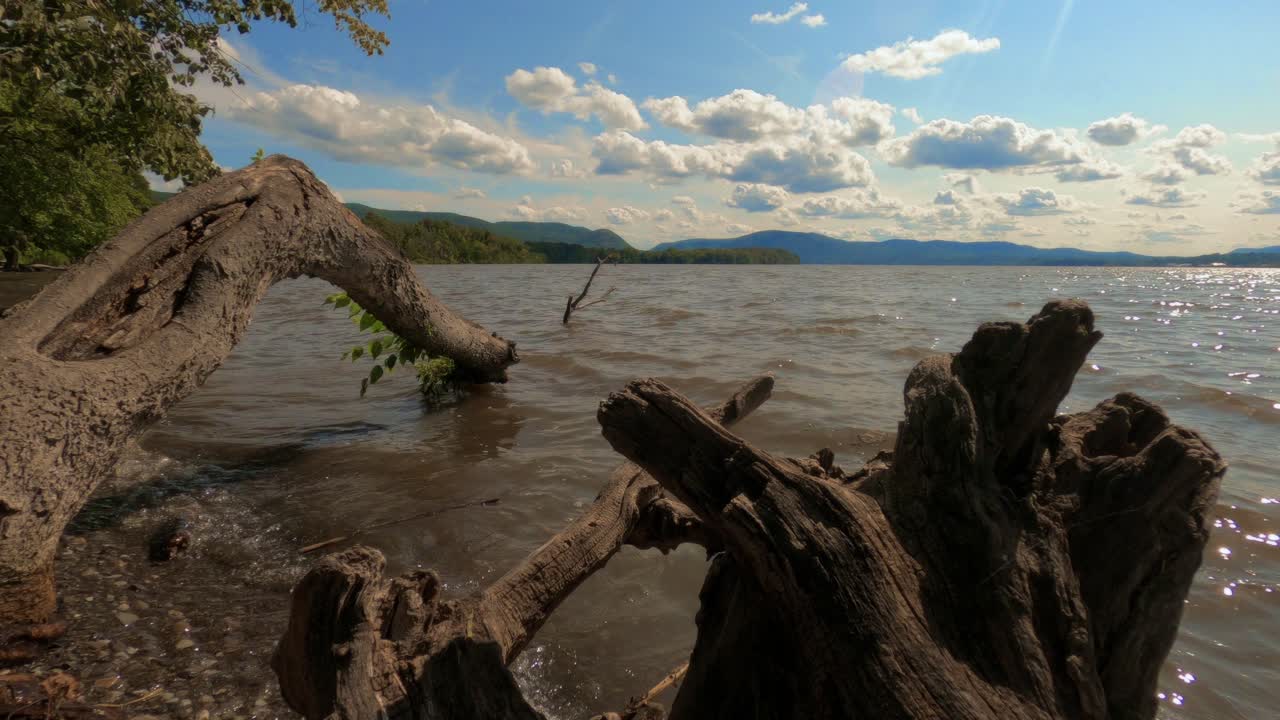 un lapso de tiempo del hermoso río hudson en el valle hudson de nueva york a principios de otoño en un día soleado con cielos azules y hermosas nubes con madera a la deriva