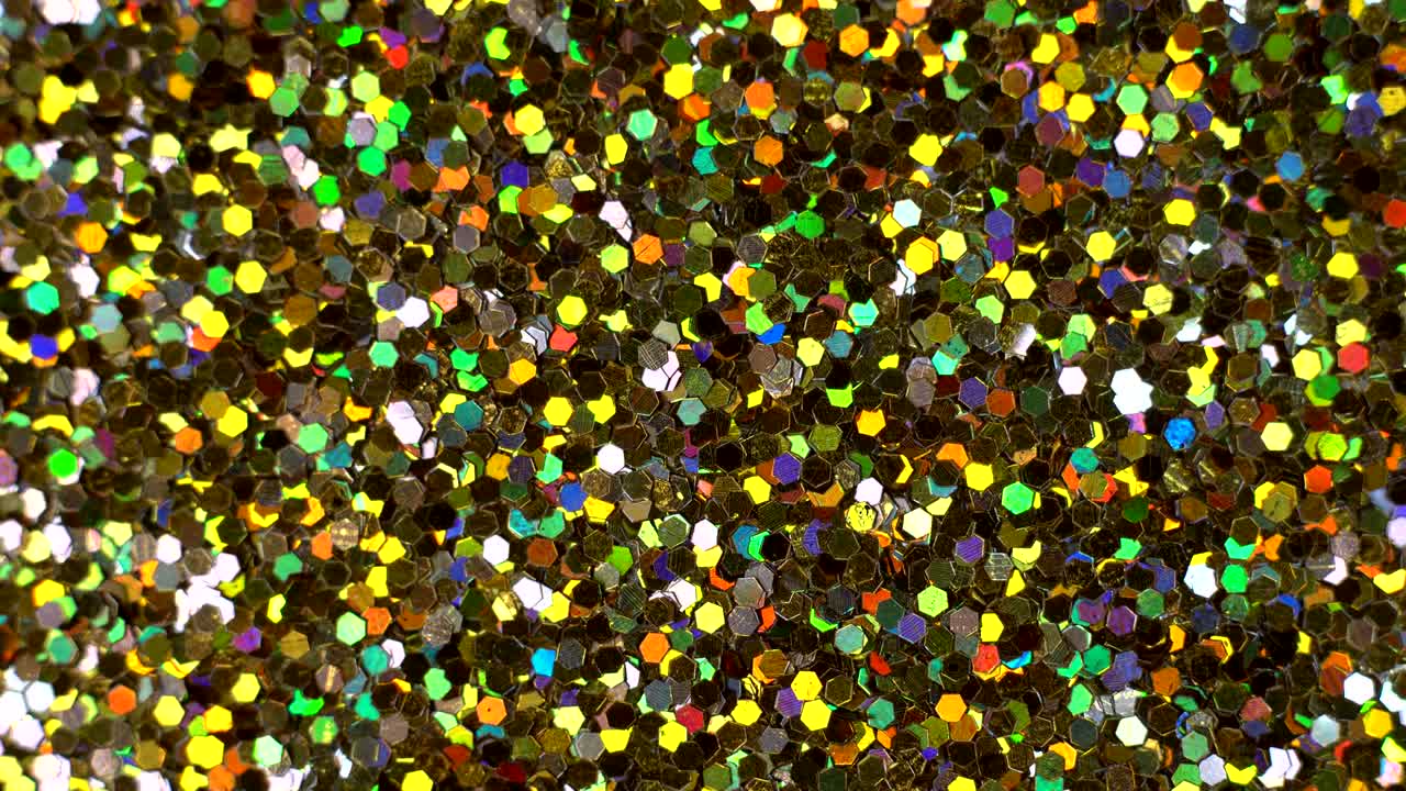 Abstract multicolor sequins glitter spin, glowing paillette close-up.
