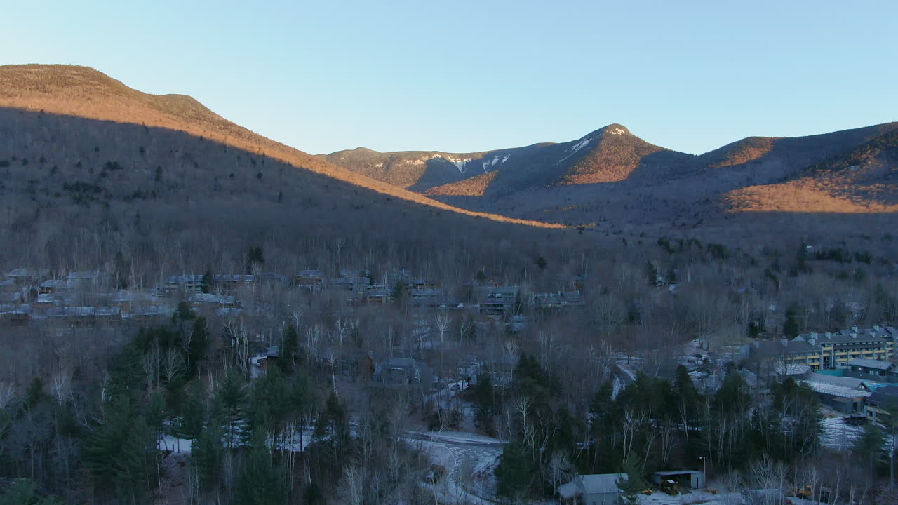 drone cinematográfico aéreo movimiento ascendente amanecer de la aldea ciudad de montaña y paisaje montañoso escénico en loon mountain resort new hampshire