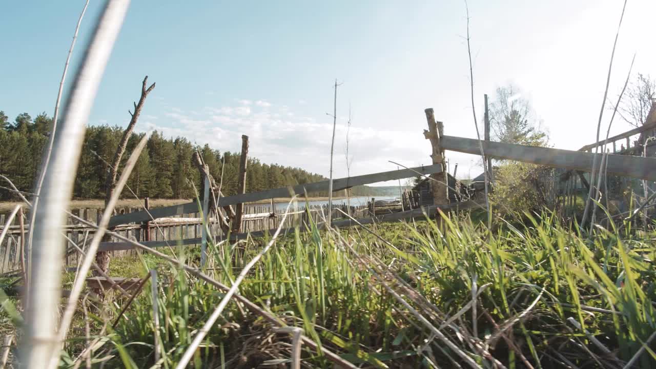 오래된 나무 울타리 와 강 에 있는 버려진 집
