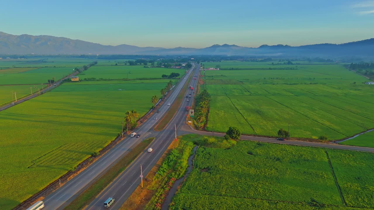 Sunset drone view of traffic flow on Duarte Highway surrounded by lush farm land