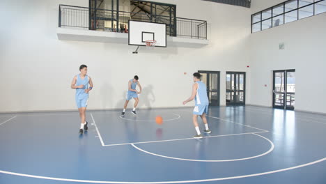 practicing dribbling and teamwork, basketball players on court in school gym