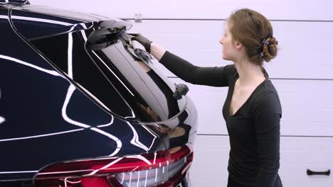 el lavador de coches profesional con guantes negros limpia el coche después de lavar y forrar la cerámica. conceptos de: trabajo profesional, varias herramientas de lavado, limpieza para brillar.