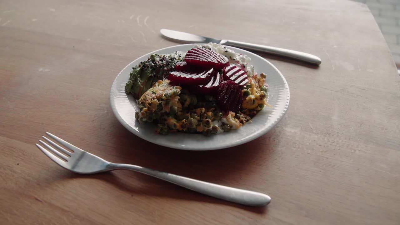 almuerzo saludable rico en proteínas con remolacha, guisantes, huevos revueltos, aguacate y queso crema granulado