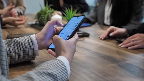 businesswoman checking information on smartphone and share it with her team on meeting