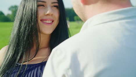 a young woman is resting in the arms with her husband looking at each other