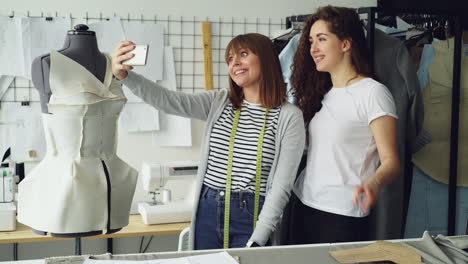 fashion designers taking a selfie with dress form