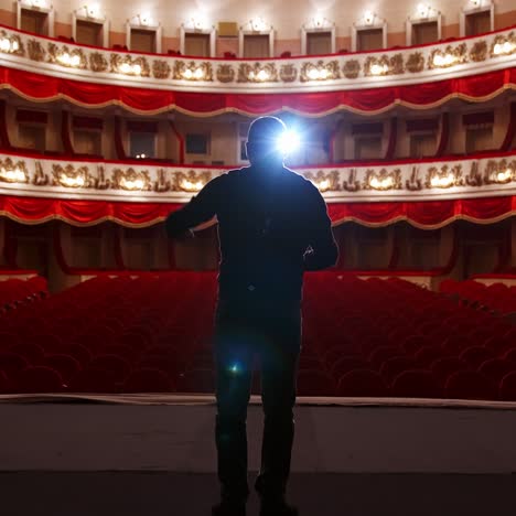 actor communicates with empty theater auditorium. no people in hall, empty chairs