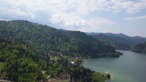 Aerial-Downwards-pan-of-lanscape-shot-of-valley-with-lake-and-woodland