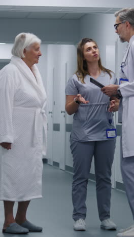 el médico y la enfermera discutiendo con el paciente en el pasillo del hospital