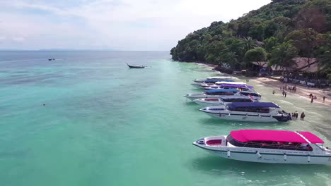 aerial view of tropical beach with speedboats and turquoise water