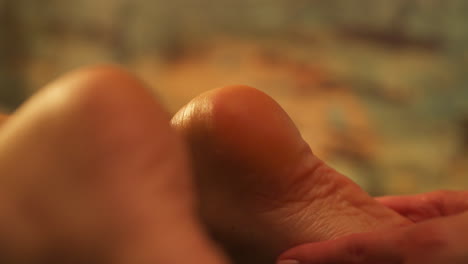 massage therapist hands massaging the sole of client's feet. - closeup shot