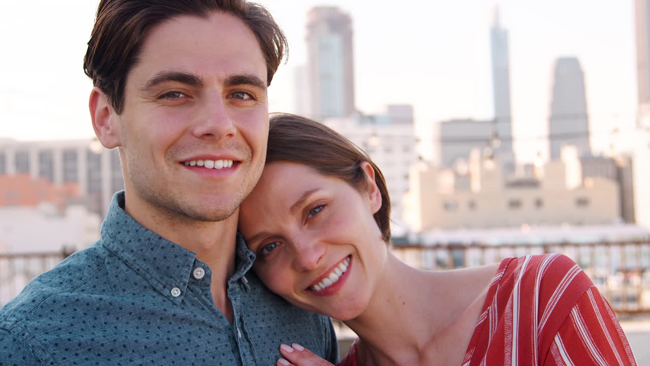 retrato de una pareja romántica en la terraza de la azotea con el horizonte de la ciudad en el fondo