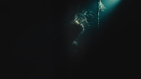 a creepy witch stands in the moody pose during the night storm
