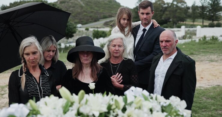 Grieving Family Standing Together at a Funeral Service