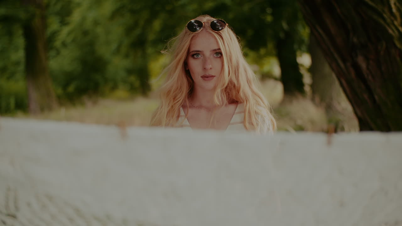 선글라스를 끼고 카메라를 똑바로 바라보는 젊은 매력적인 여성의 초상화