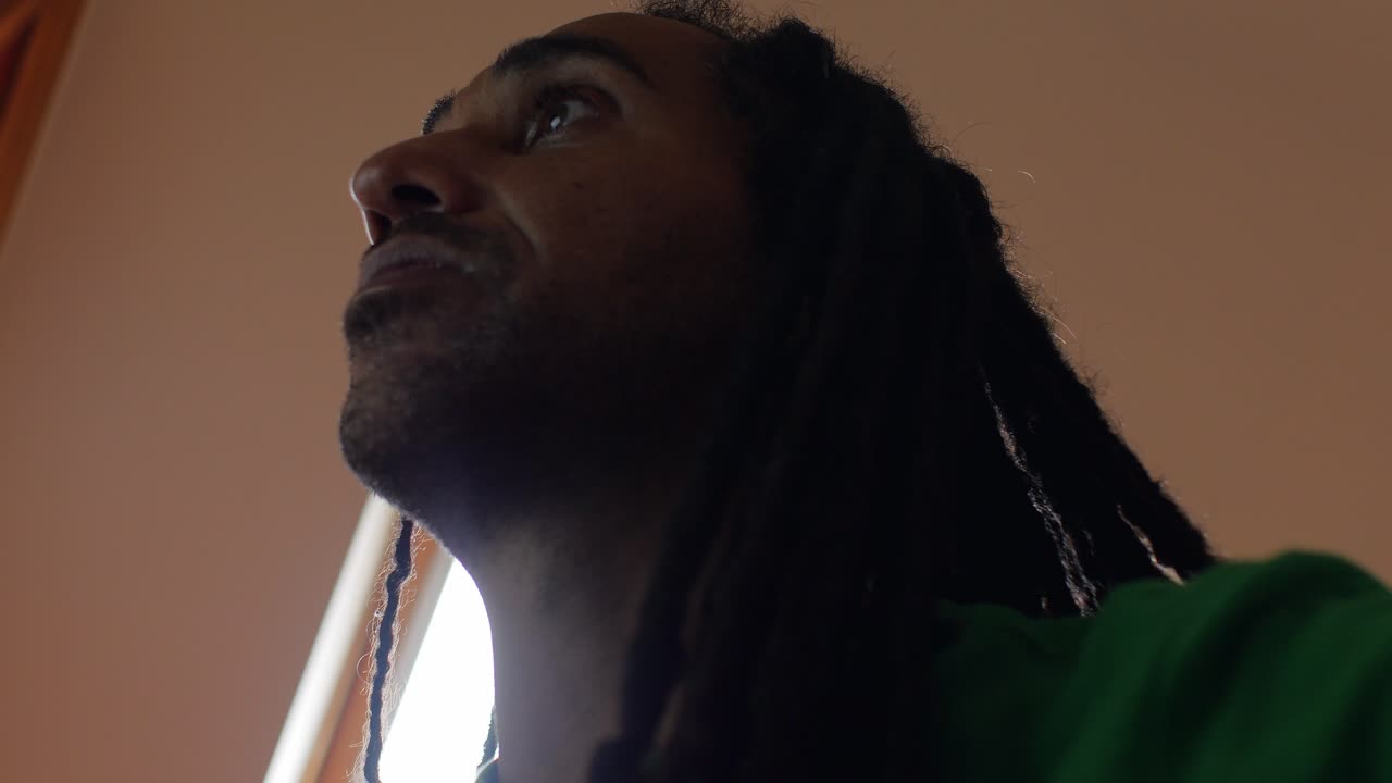 retrato de un hombre con dreadlocks centrado en una tarea informática