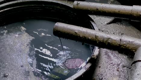 black chemical wastewater pouring on the storage tank coming out from pipe from industrial processes on wwtp wastewater treatment procedure